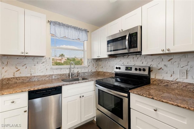 kitchen with white cabinets, sink, light stone countertops, and stainless steel appliances