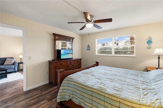 bedroom with a textured ceiling, ceiling fan, and dark wood-type flooring