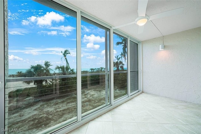 unfurnished sunroom featuring ceiling fan