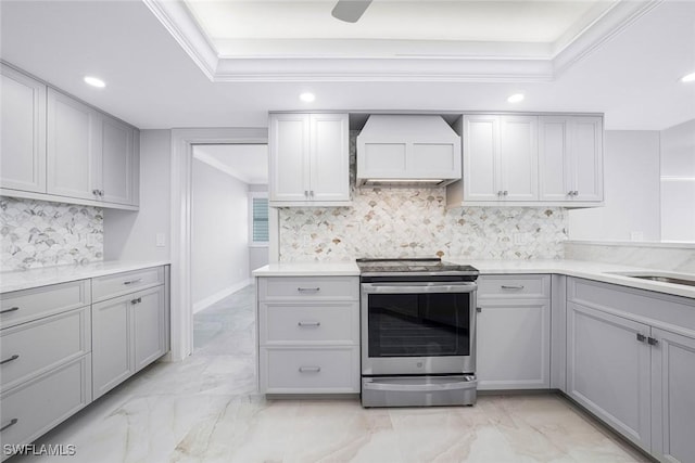 kitchen featuring gray cabinetry, backsplash, stainless steel range with electric cooktop, custom range hood, and ornamental molding