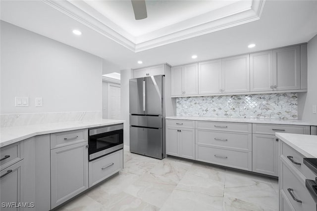 kitchen featuring gray cabinets, stainless steel refrigerator, built in microwave, and crown molding