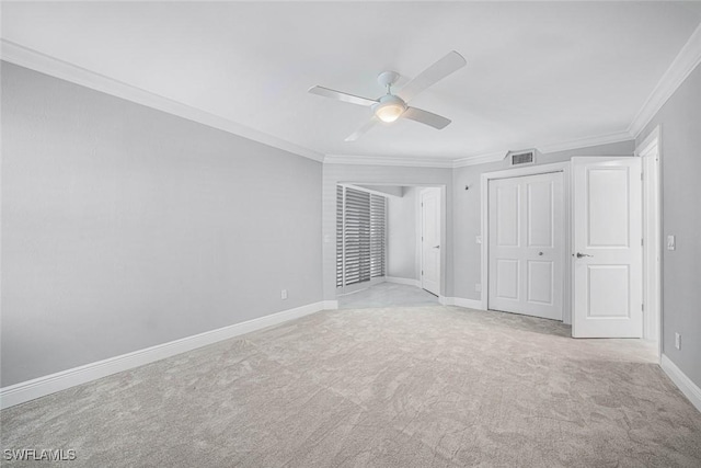 unfurnished bedroom featuring ceiling fan, light colored carpet, crown molding, and a closet