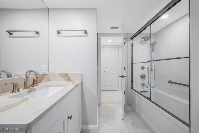 bathroom with vanity and enclosed tub / shower combo