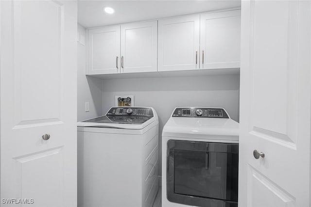 laundry area with washer and dryer and cabinets