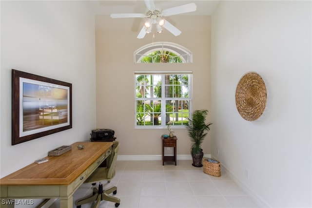 tiled office space with ceiling fan and a towering ceiling