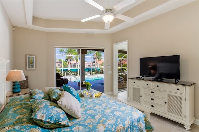 bedroom with access to exterior, a tray ceiling, ceiling fan, and light tile patterned flooring