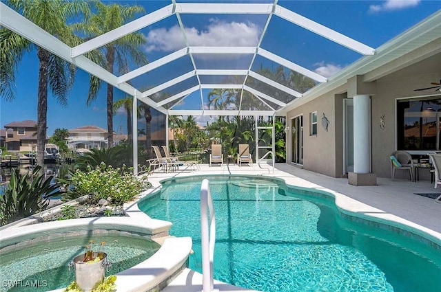 view of swimming pool featuring glass enclosure, a patio, and a jacuzzi