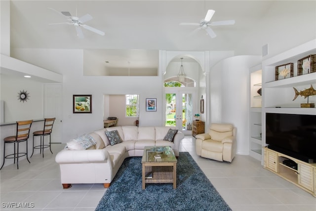 living room with a towering ceiling, french doors, light tile patterned floors, and built in features