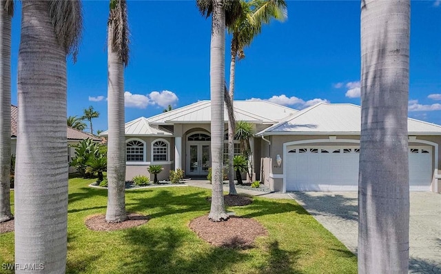 ranch-style home with french doors, a front lawn, and a garage