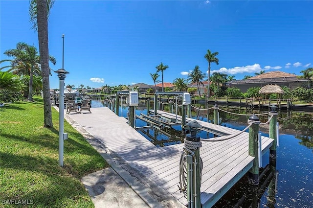 dock area featuring a lawn and a water view