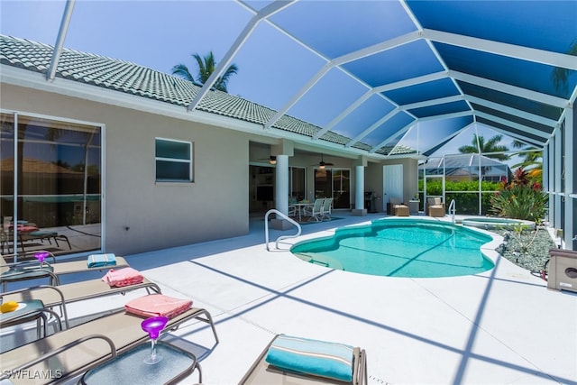 view of swimming pool with ceiling fan, a lanai, and a patio