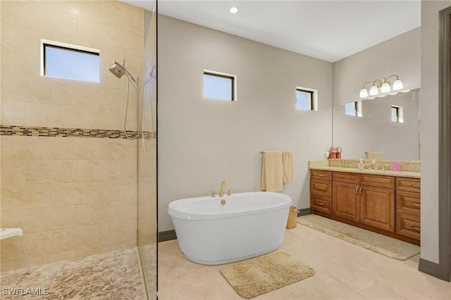 bathroom featuring plus walk in shower, tile patterned flooring, and vanity