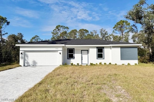 single story home featuring a garage and a front lawn