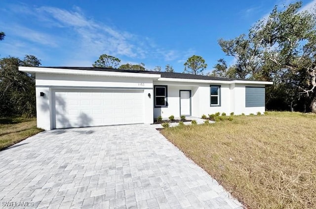 ranch-style house featuring a front lawn and a garage