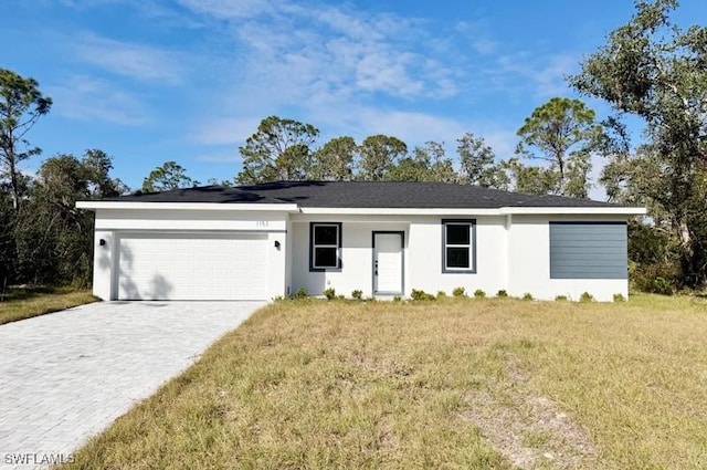 ranch-style house featuring a front lawn and a garage