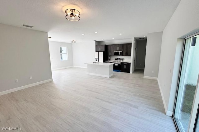 unfurnished living room featuring light wood-type flooring and a textured ceiling