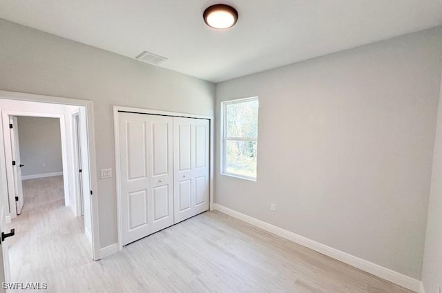 unfurnished bedroom featuring a closet and light hardwood / wood-style floors