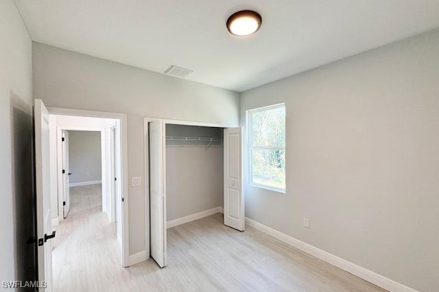 unfurnished bedroom featuring light hardwood / wood-style flooring and a closet