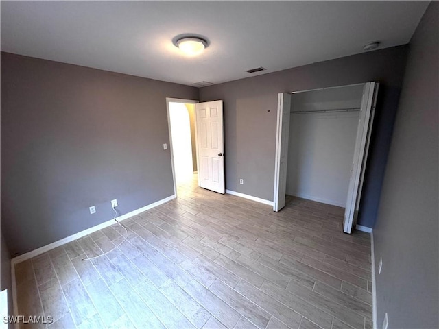 unfurnished bedroom featuring a closet and light hardwood / wood-style flooring