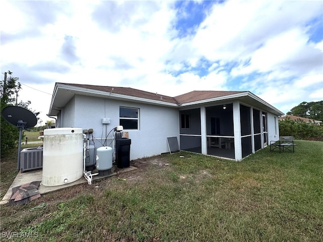 rear view of house featuring a lawn, cooling unit, and a sunroom