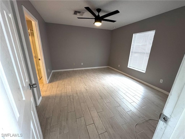 empty room with ceiling fan and light hardwood / wood-style flooring