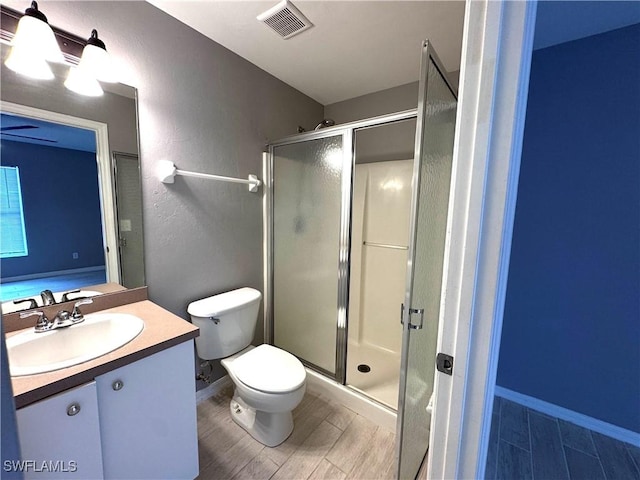 bathroom featuring hardwood / wood-style floors, vanity, toilet, and an enclosed shower