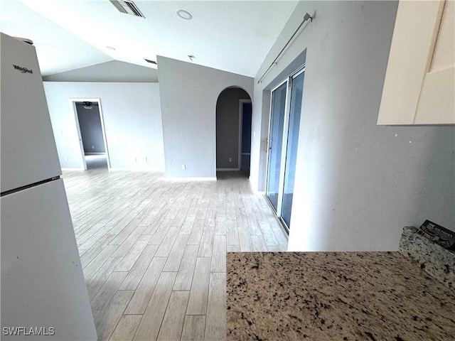 interior space featuring light hardwood / wood-style floors and vaulted ceiling