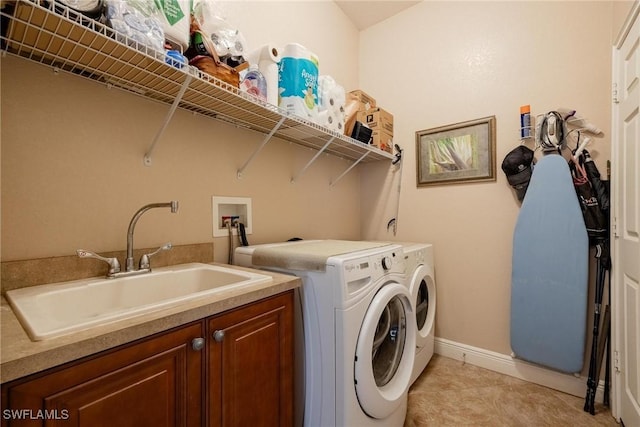 washroom with cabinets, light tile patterned floors, washer and dryer, and sink