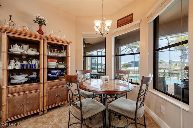 dining area with light tile patterned flooring and a notable chandelier