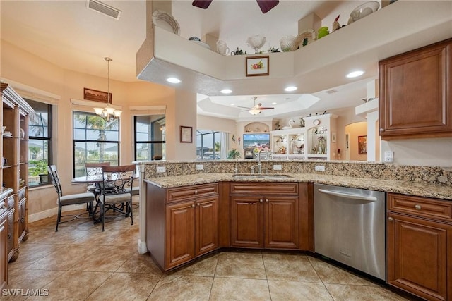 kitchen with sink, hanging light fixtures, light stone counters, stainless steel dishwasher, and kitchen peninsula