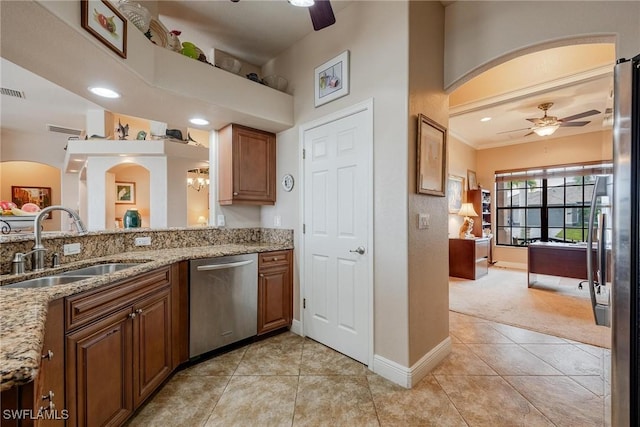 kitchen featuring ceiling fan, sink, stainless steel appliances, light stone counters, and light tile patterned flooring