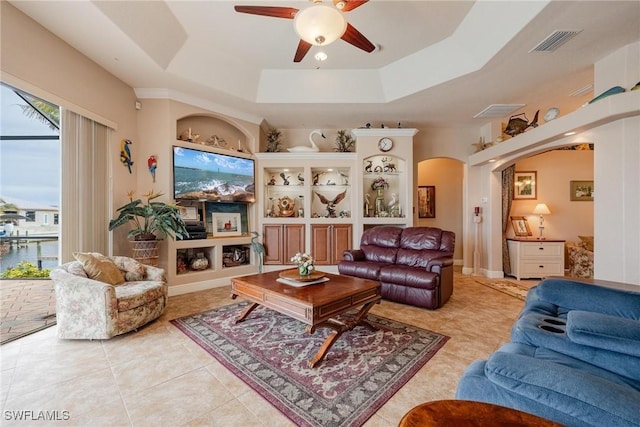 living room featuring ceiling fan, light tile patterned floors, and a tray ceiling