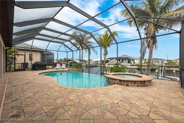 view of pool with an in ground hot tub, area for grilling, a water view, glass enclosure, and a patio area