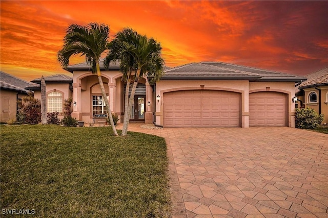 mediterranean / spanish house with a garage and a yard