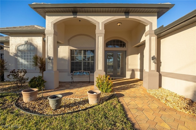 entrance to property featuring a porch and french doors