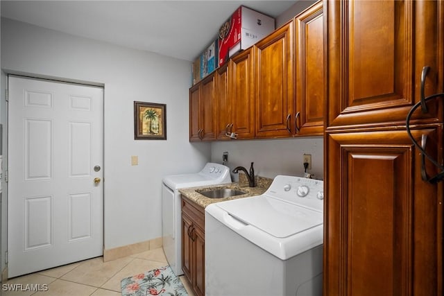 laundry area featuring cabinets, light tile patterned floors, washer and clothes dryer, and sink