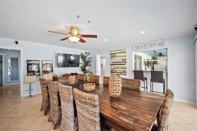 tiled dining room featuring ceiling fan and ornamental molding