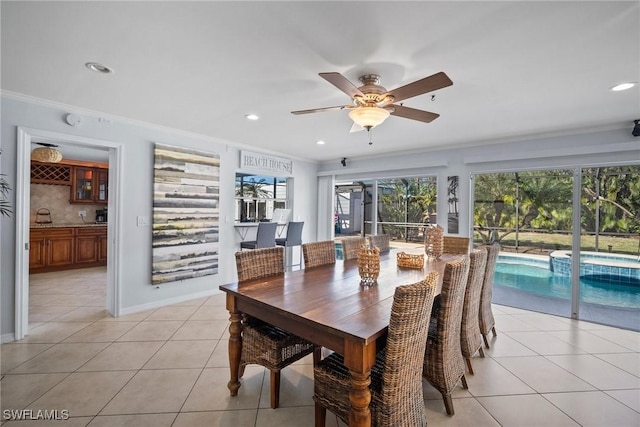 tiled dining room featuring crown molding and ceiling fan