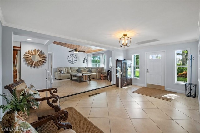 tiled foyer featuring ceiling fan with notable chandelier and crown molding