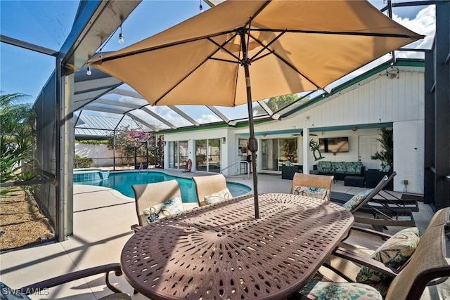 view of pool with a lanai, outdoor lounge area, and a patio