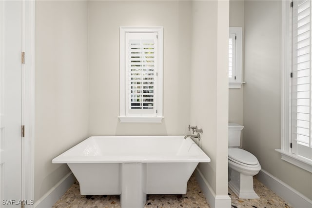 bathroom featuring a tub and toilet