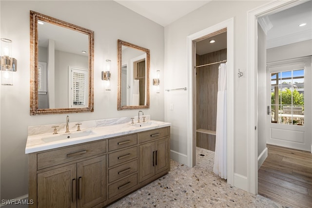 bathroom featuring walk in shower, hardwood / wood-style floors, vanity, and ornamental molding