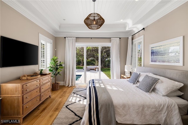 bedroom featuring access to outside, a tray ceiling, light hardwood / wood-style floors, and ornamental molding