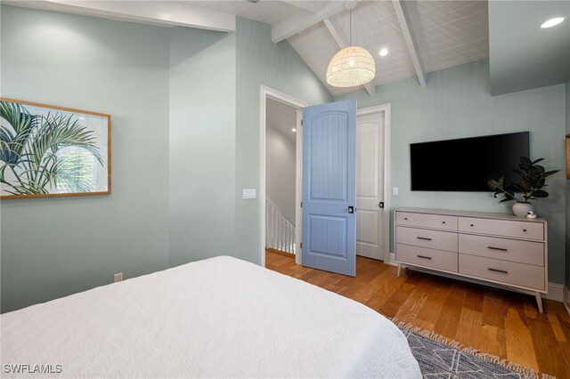 bedroom featuring vaulted ceiling with beams and light hardwood / wood-style flooring