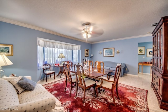 tiled dining room featuring a textured ceiling, ceiling fan, and crown molding