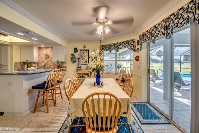 tiled dining space featuring ceiling fan and ornamental molding