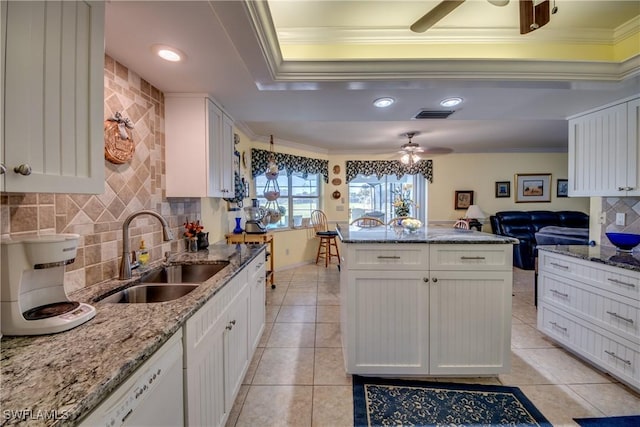 kitchen featuring white cabinets, crown molding, and sink