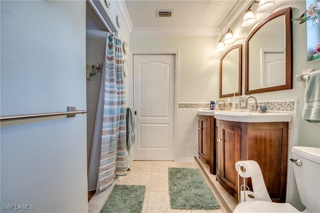 bathroom featuring tile patterned flooring, vanity, ornamental molding, and tile walls