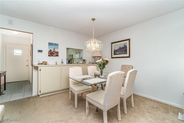 dining area featuring a notable chandelier and light colored carpet