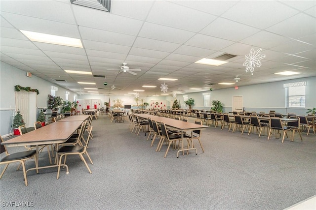 carpeted dining room featuring a drop ceiling and ceiling fan